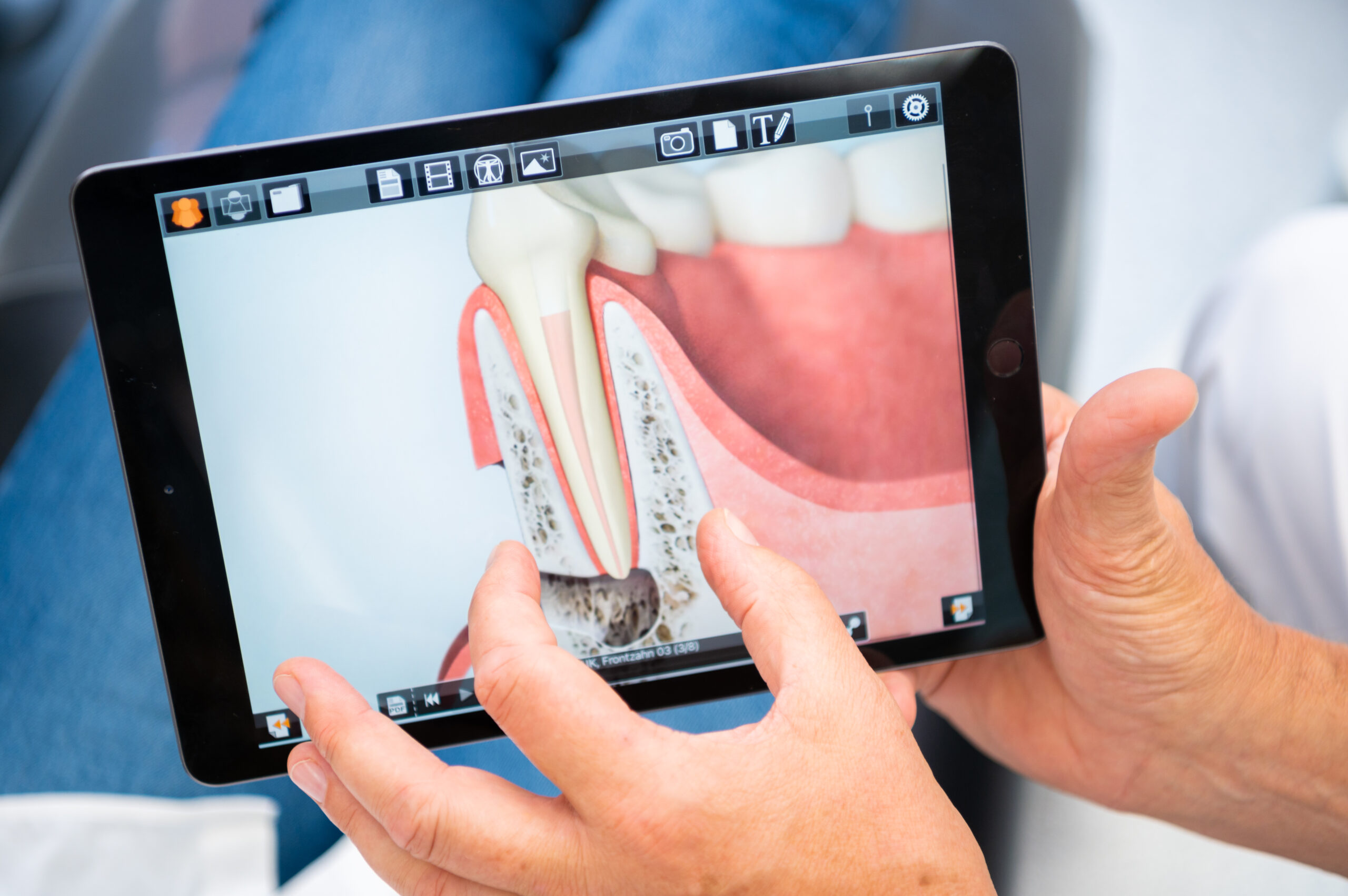 Der Arzt geht mit dem Kunden die digitale Patientenerklärung auf dem Tablet durch
